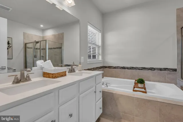 a bathroom with a tub sink and mirror