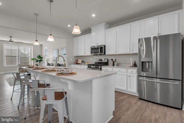 a kitchen with stainless steel appliances a refrigerator a stove a sink and a refrigerator