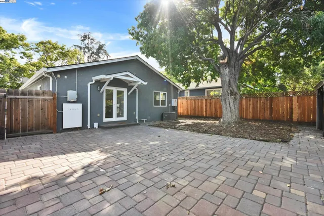 a view of a house with a yard and large tree