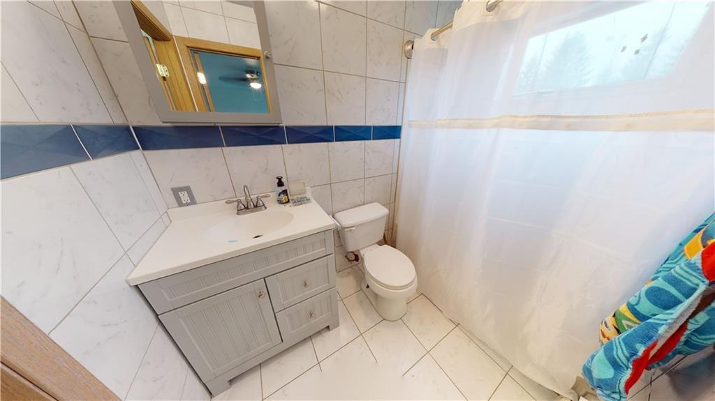 3902 Knoyle Road Erie, PA 16510 - Photo 24 of 25 a bathroom with a sink a toilet and a shower curtain