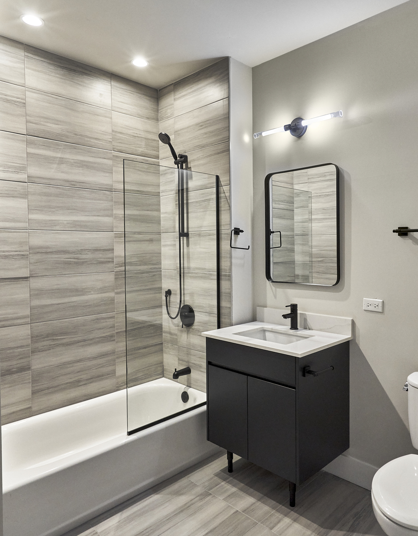 503 East Pershing Road, Unit 203 Chicago, IL 60653 - Photo 18 of 29 a bathroom with a double vanity sink toilet mirror and bathtub