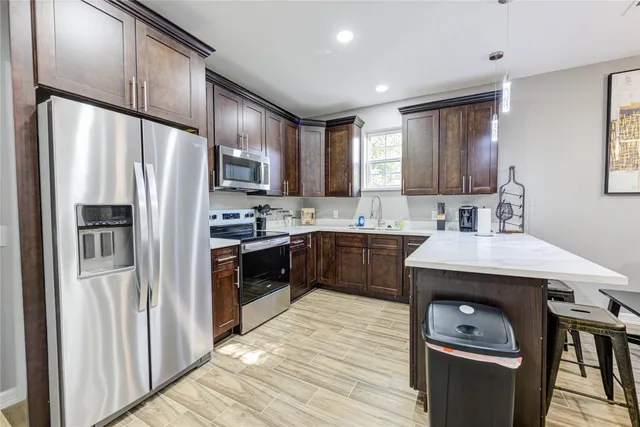 a kitchen with stainless steel appliances granite countertop a refrigerator sink and cabinets