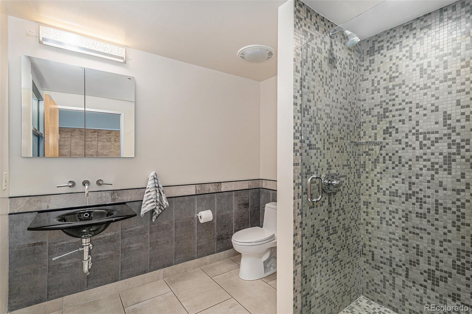 1401 Wewatta Street, Unit 1202 Denver, CO 80202 - Photo 23 of 50 a bathroom with a toilet a sink and mirror