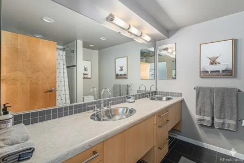 a bathroom with a sink double vanity granite tub shower and a mirror