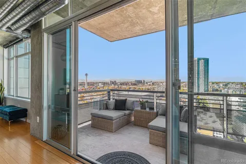 a view of a balcony with furniture and a floor to ceiling window