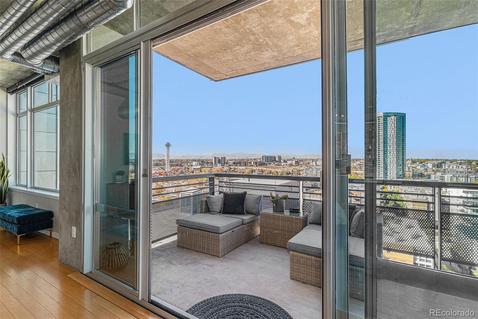 1401 Wewatta Street, Unit 1202 Denver, CO 80202 - Photo 27 of 50 a view of a balcony with furniture and a floor to ceiling window
