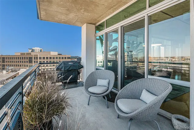 a view of a balcony with chairs and a potted plant