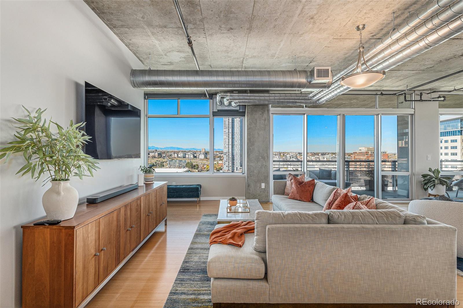 1401 Wewatta Street, Unit 1202 Denver, CO 80202 - Photo 6 of 50 a living room with furniture and a flat screen tv
