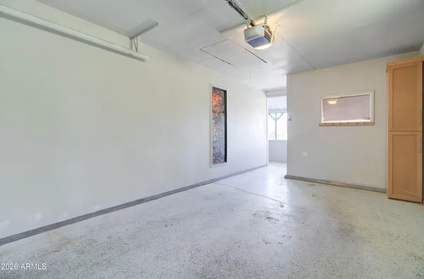an empty room with a ceiling fan and window