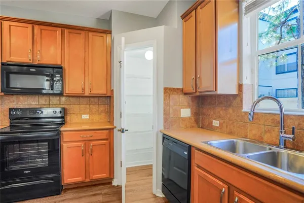a kitchen with stainless steel appliances a stove cabinets and wooden floor