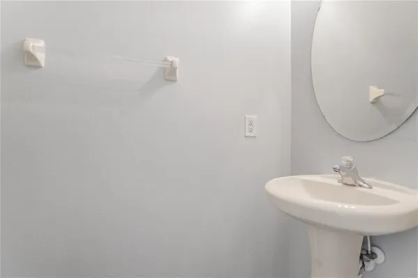 a view of a hallway with wooden floor and a bathroom