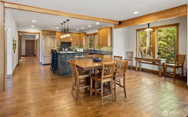 a dining hall with stainless steel appliances a dining table and chairs with wooden floor