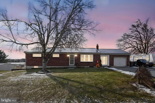 a front view of house with yard and trees around