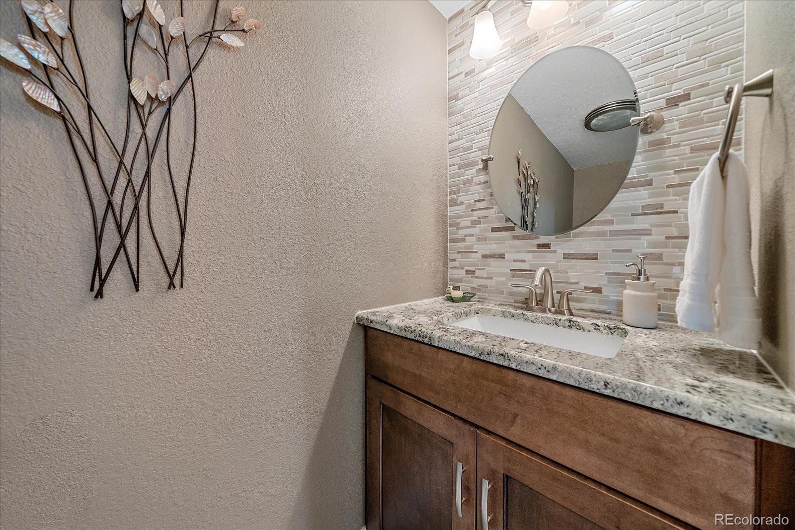 930 Reed Court Lakewood, CO 80214 - Photo 18 of 41 a bathroom with a granite countertop sink and a mirror