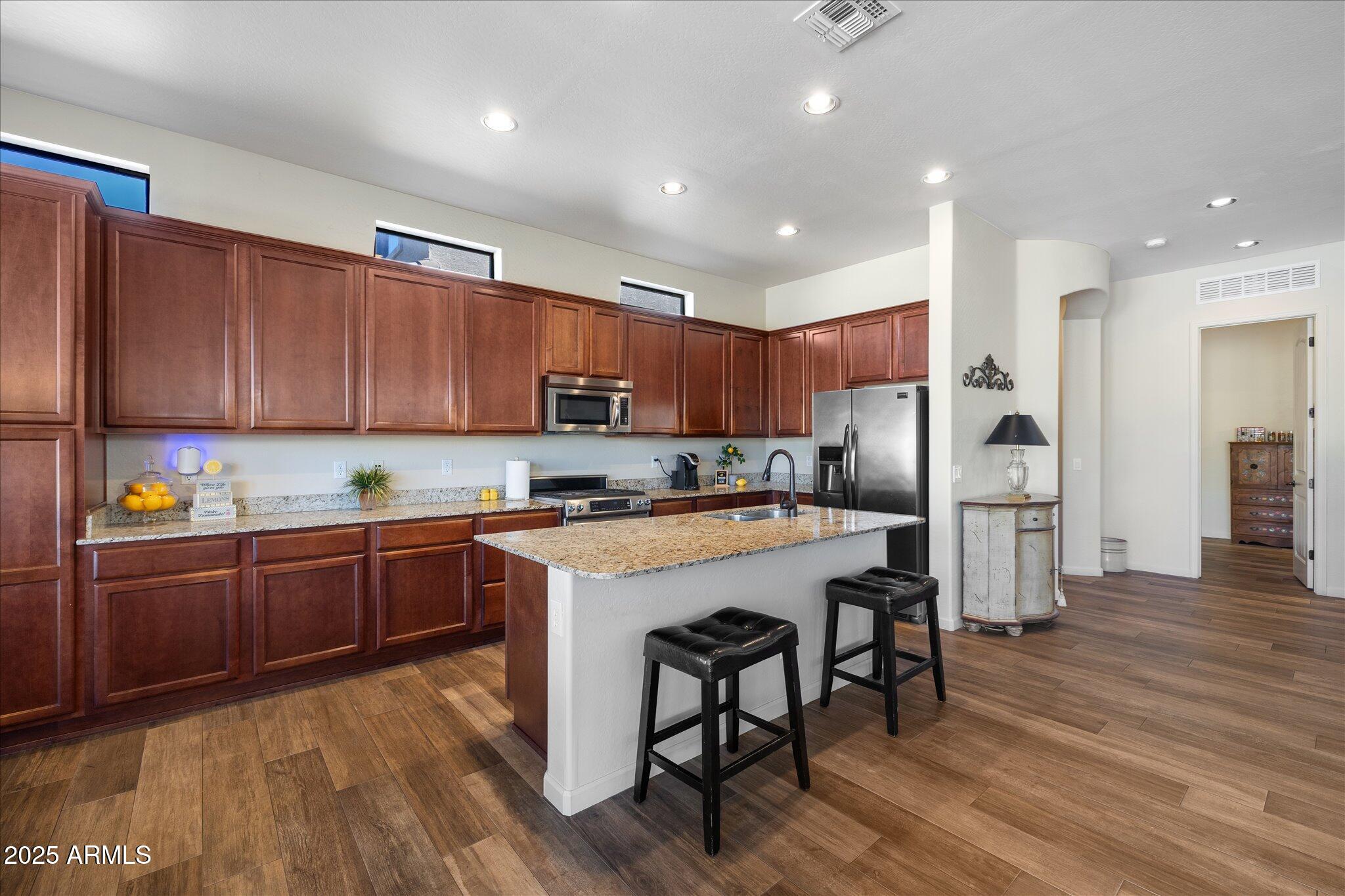 8536 East Inca Street Mesa, AZ 85207 - Photo 10 of 44 a kitchen with stainless steel appliances granite countertop a refrigerator a stove top oven a sink and cabinets