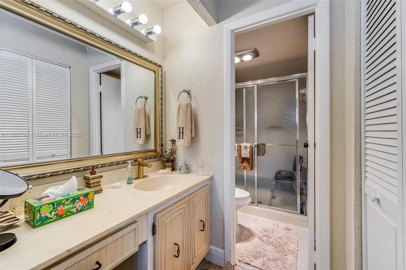 3671 Environ Boulevard, Unit 169 Lauderhill, FL 33319 - Photo 13 of 23 a bathroom with a sink a mirror and a shower