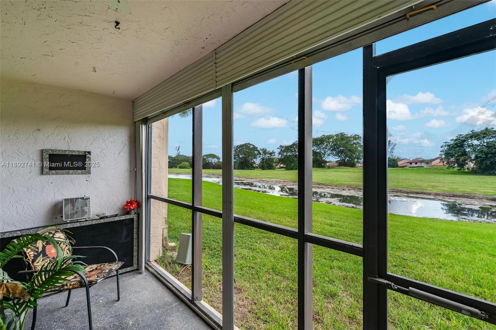 3671 Environ Boulevard, Unit 169 Lauderhill, FL 33319 - Photo 18 of 23 a living room with hardwood floor and a floor to ceiling window
