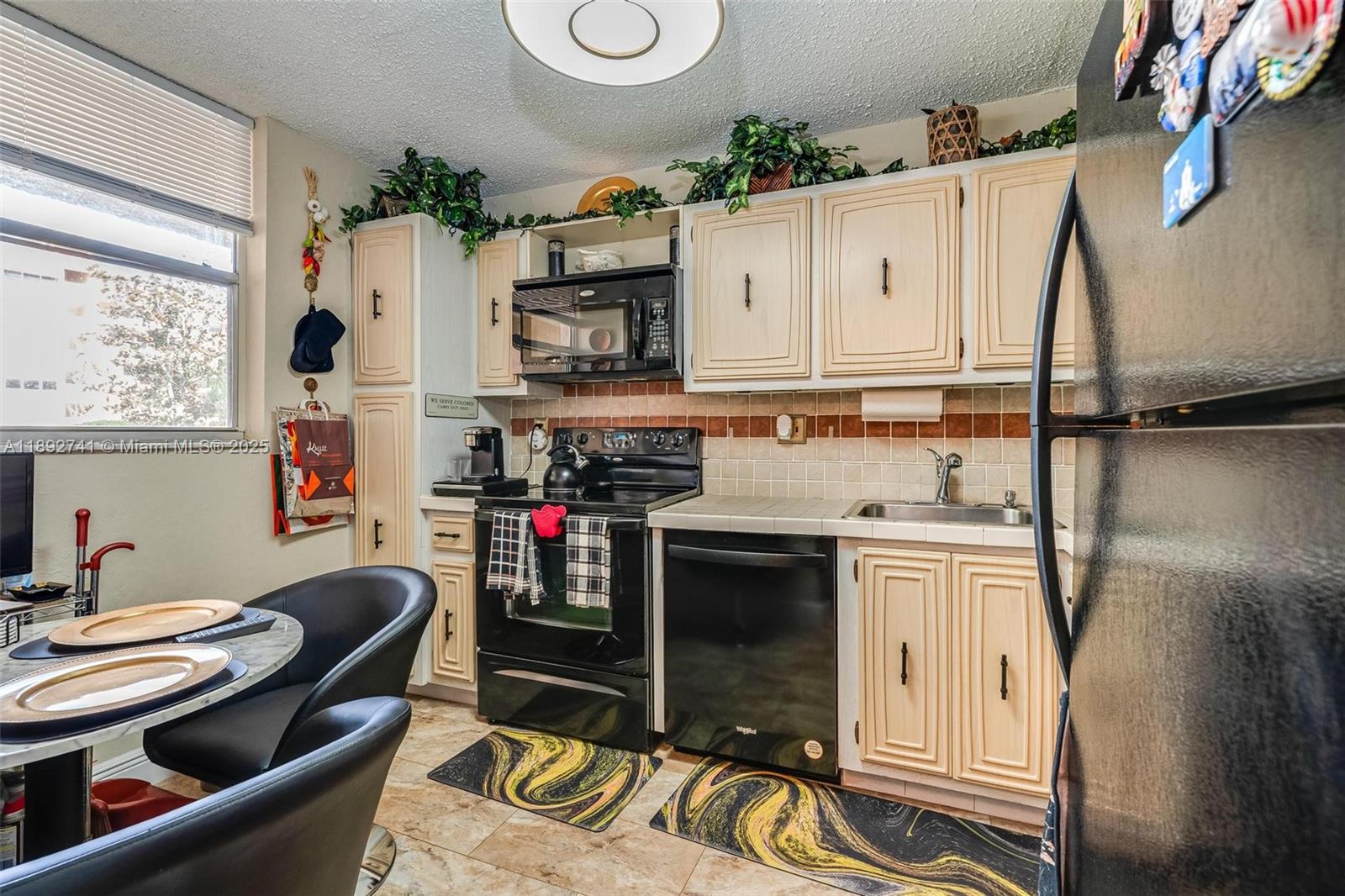 3671 Environ Boulevard, Unit 169 Lauderhill, FL 33319 - Photo 3 of 23 a kitchen with stainless steel appliances granite countertop a stove and a refrigerator