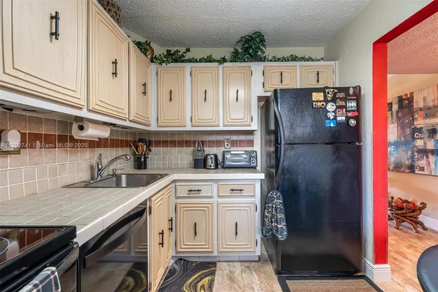 a kitchen with stainless steel appliances granite countertop a refrigerator sink and cabinets