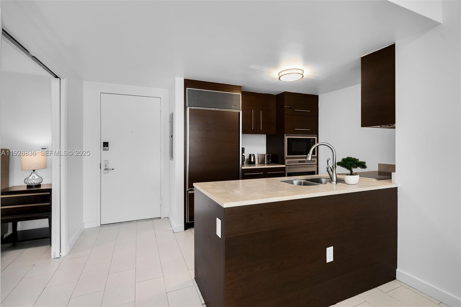 485 Brickell Avenue, Unit 1709 Miami, FL 33131 - Photo 11 of 22 a kitchen with stainless steel appliances granite countertop a sink and a refrigerator