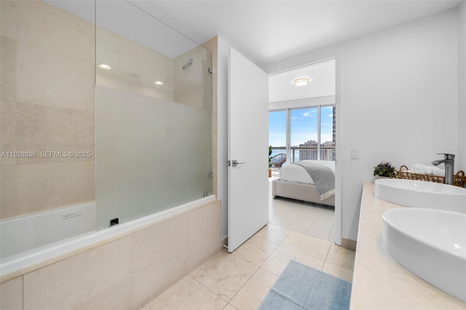 485 Brickell Avenue, Unit 1709 Miami, FL 33131 - Photo 17 of 22 a en suite bathroom with a tub shower and sink