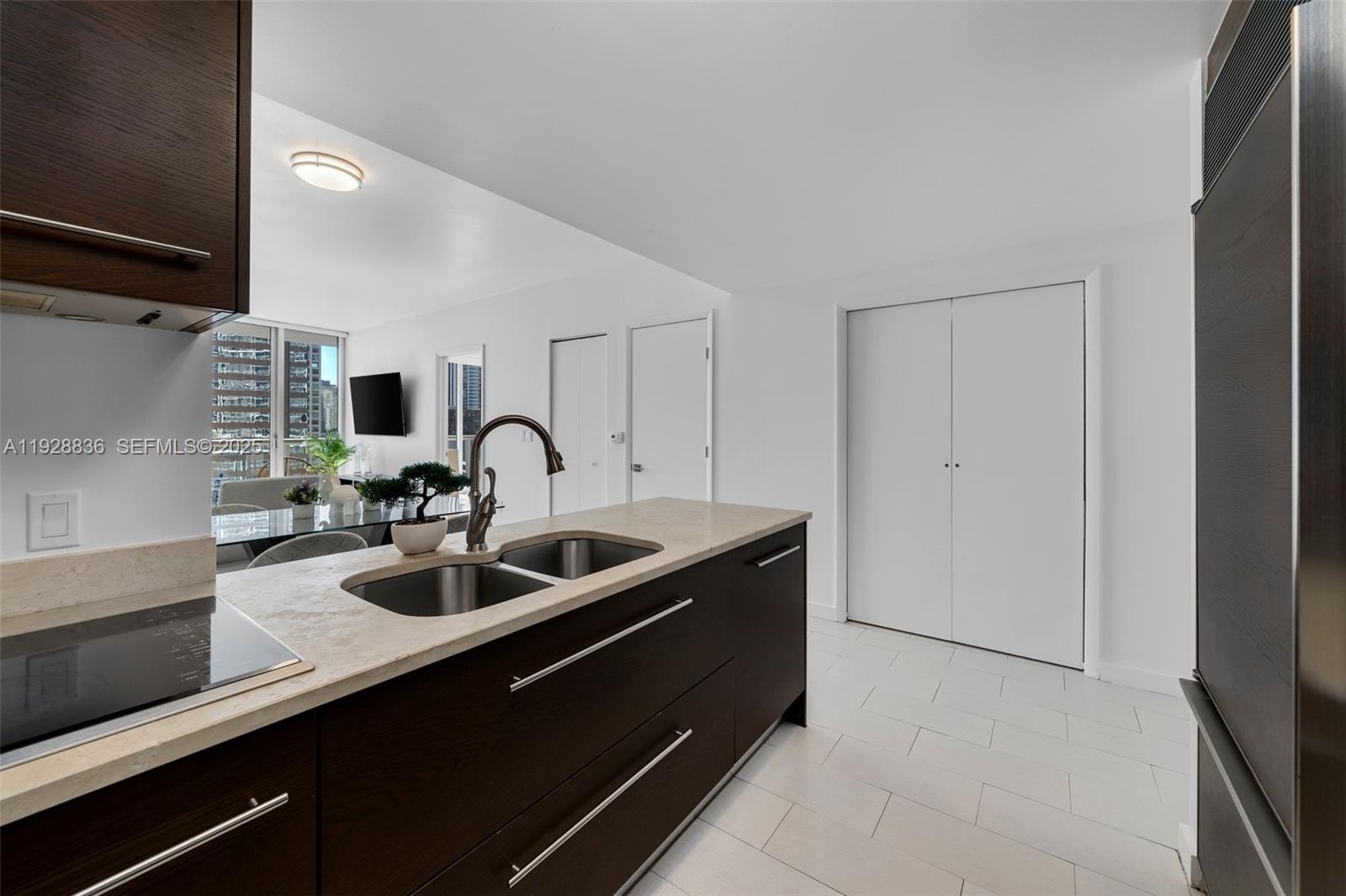 485 Brickell Avenue, Unit 1709 Miami, FL 33131 - Photo 19 of 22 a kitchen with kitchen island a sink and a stove with wooden floor
