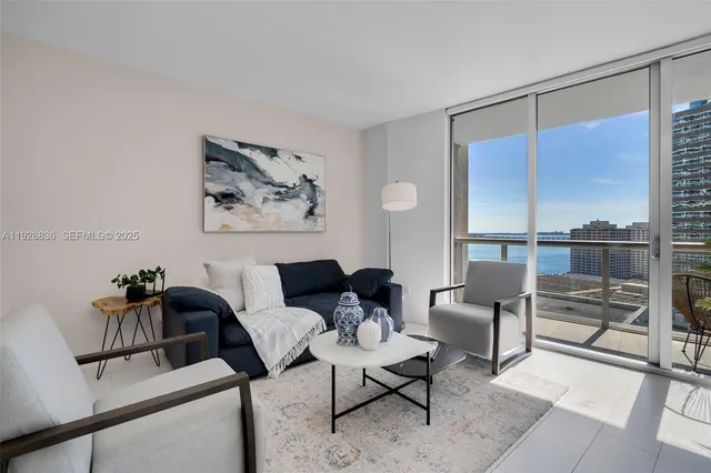 a living room with furniture and a floor to ceiling window