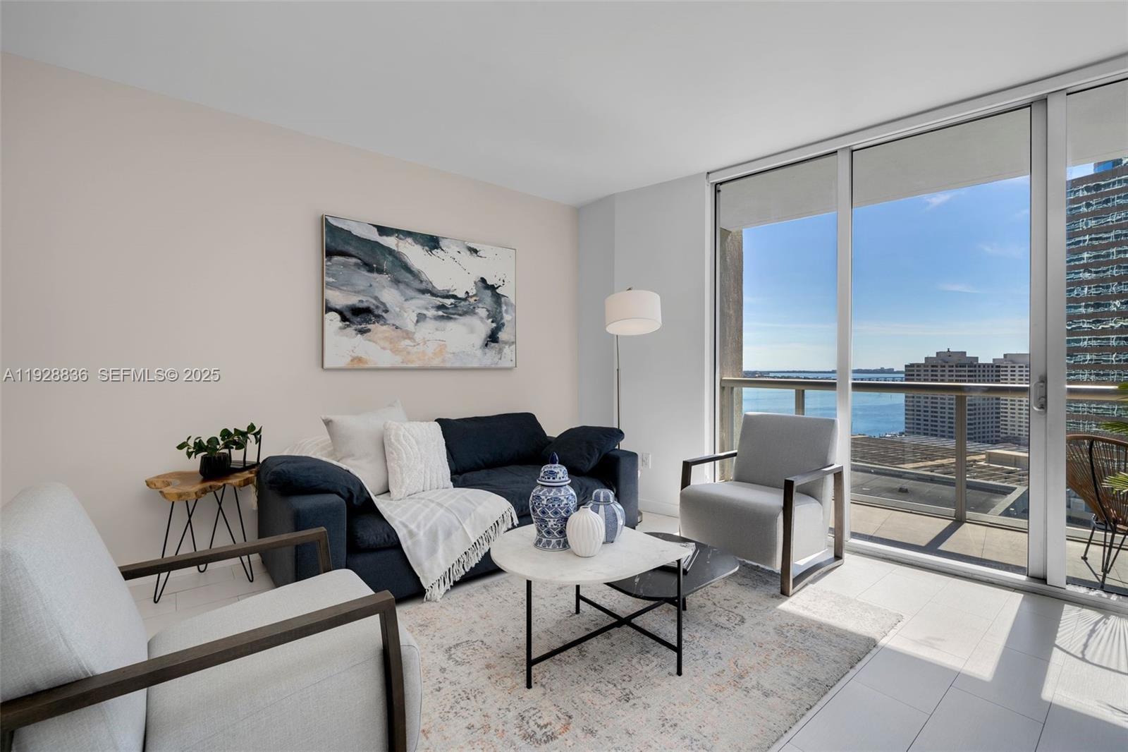 485 Brickell Avenue, Unit 1709 Miami, FL 33131 - Photo 2 of 22 a living room with furniture and a floor to ceiling window