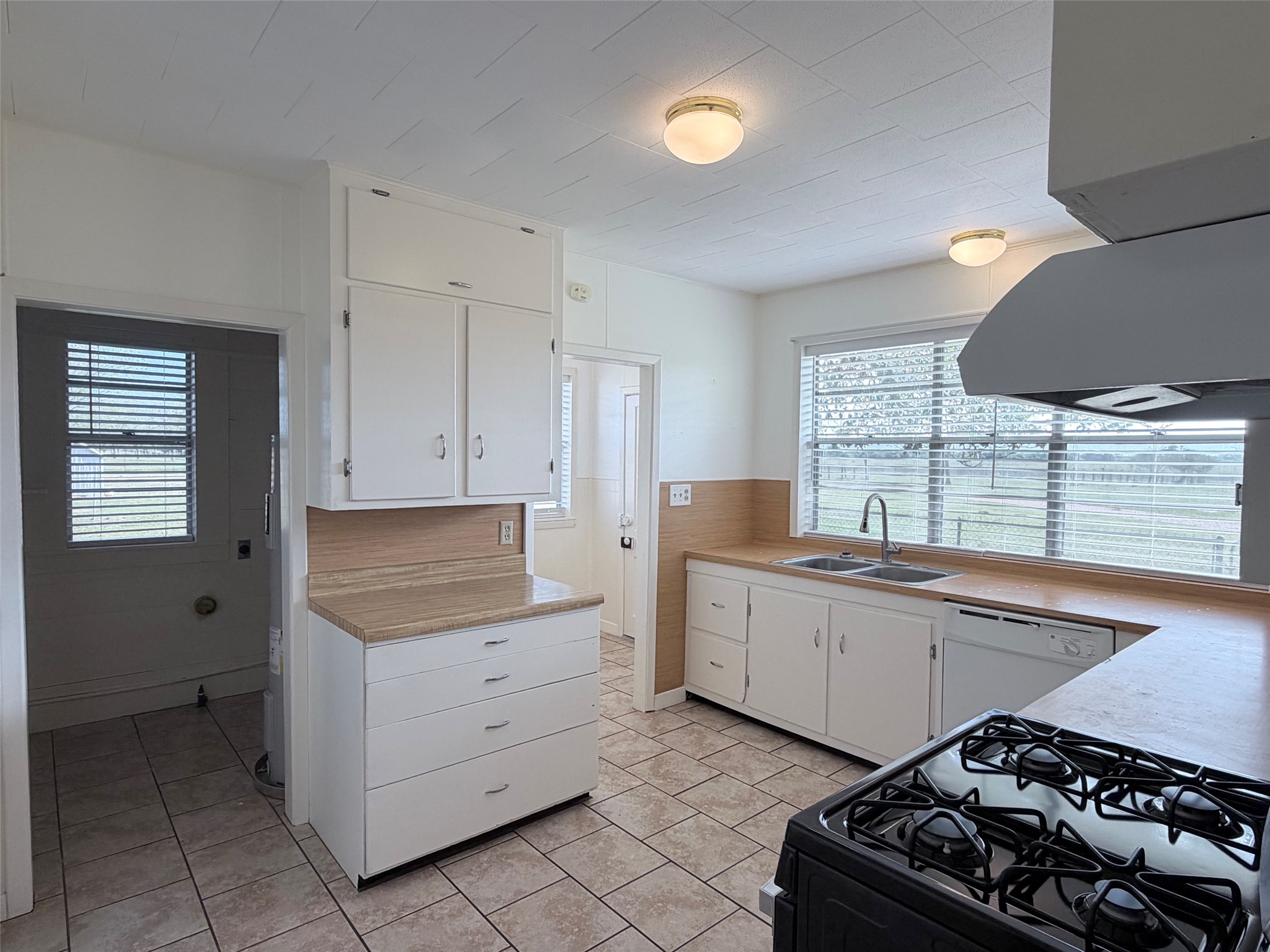 500 Greasy Bend Road Smithville, TX 78957 - Photo 6 of 21 Kitchen featuring white cabinetry, light-toned countertops, and tile flooring