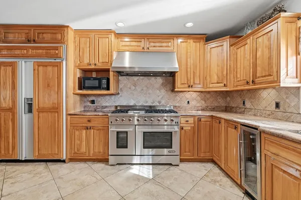 a large kitchen with granite countertop a sink window and cabinets