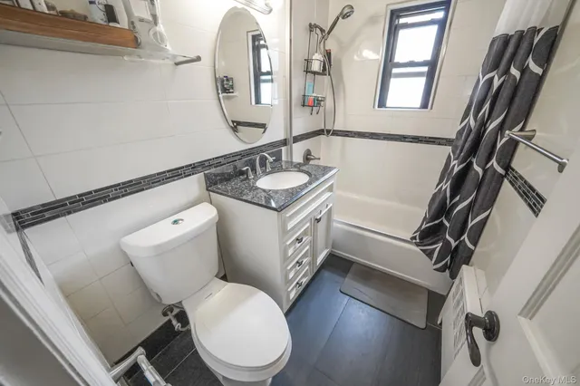 a bathroom with a granite countertop toilet sink and mirror