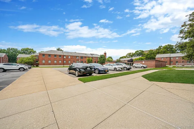 a view of swimming pool with outdoor seating and buildings in the background