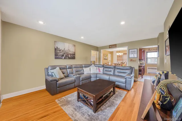 a living room with furniture a flat screen tv and a table