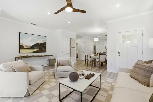 a living room with furniture and a view of kitchen