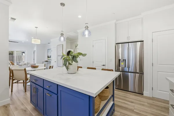 a kitchen with kitchen island a counter top space refrigerator and cabinets