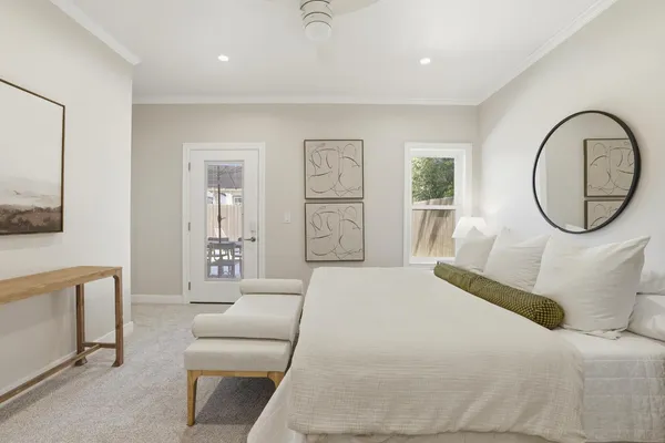 a bedroom with a bed mirror and window