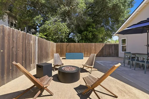 a view of a patio with table and chairs with wooden floor and fence