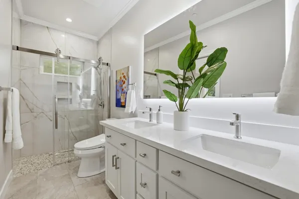 a bathroom with a double vanity sink toilet and shower