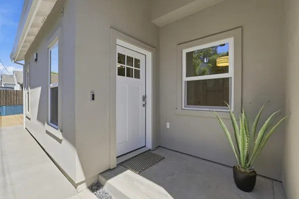 a view of a hallway with wooden floor and a potted plant