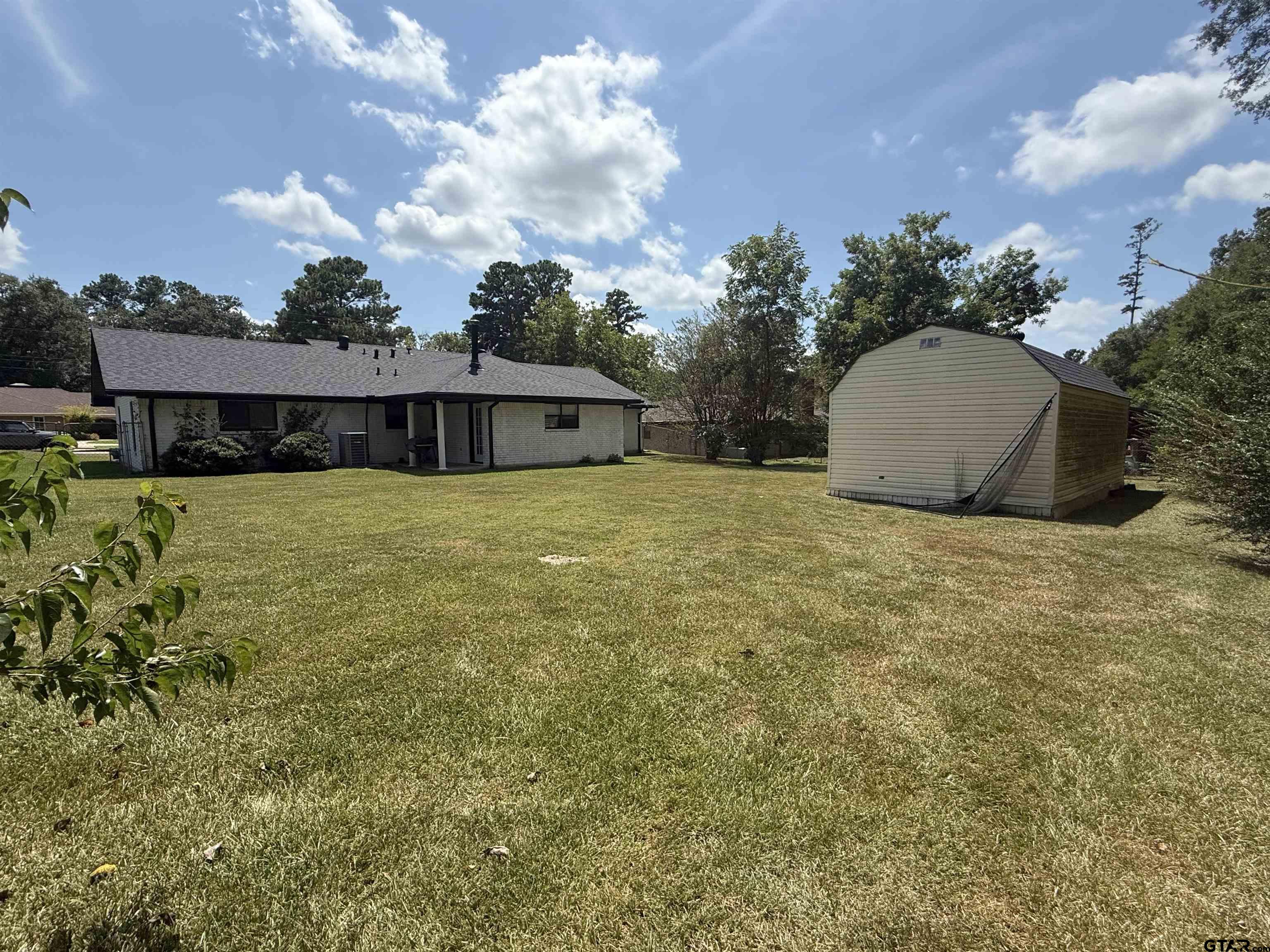 608 Pine Street Henderson, TX 75654 - Photo 20 of 46 a view of a house with a yard and potted plants