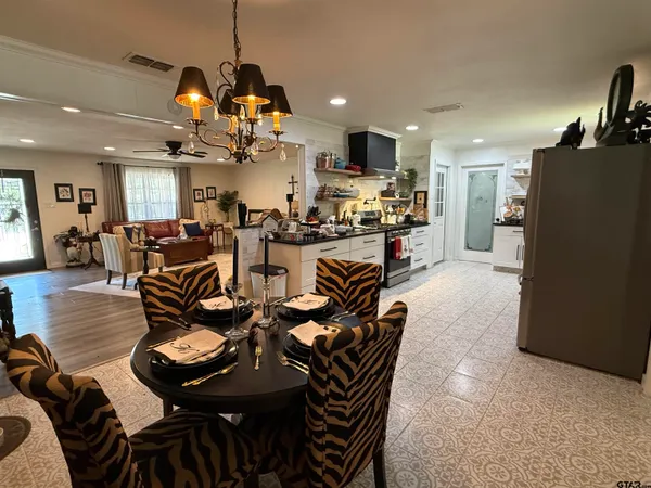 a view of a dining room and livingroom with furniture wooden floor a chandelier