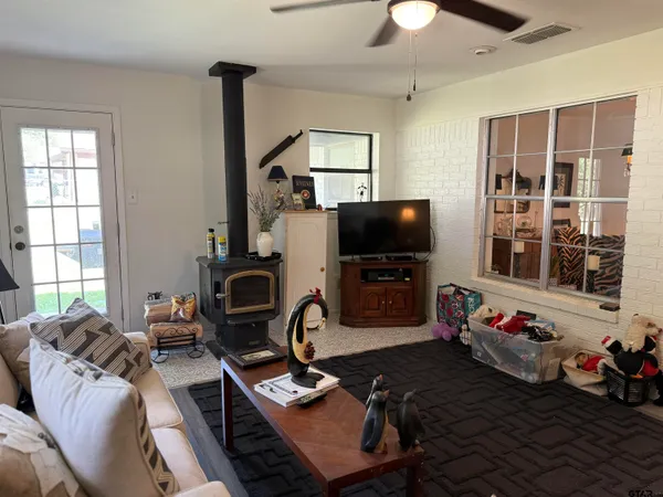 a living room with furniture a flat screen tv and a chandelier