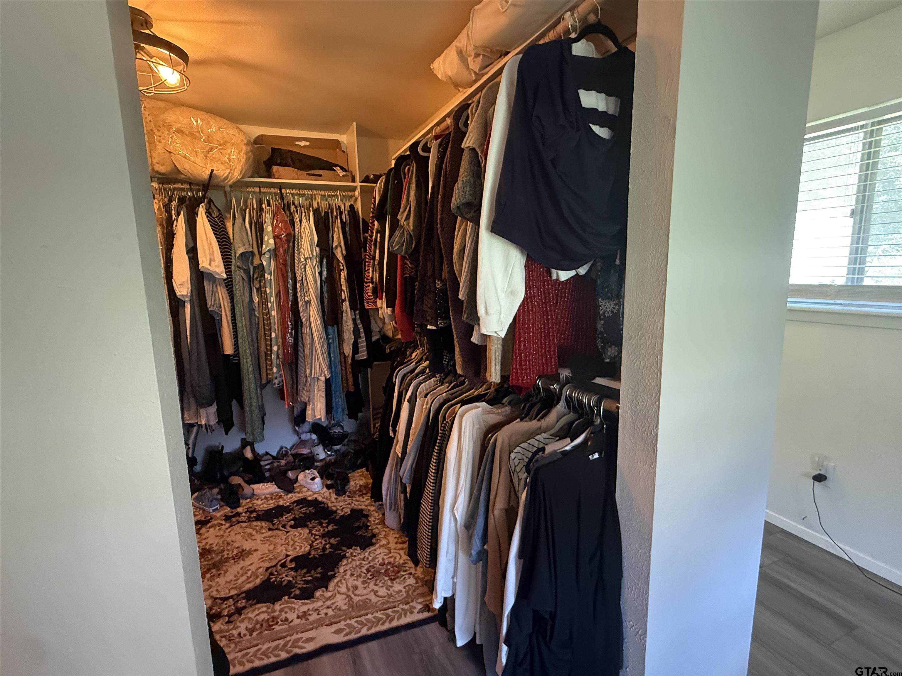 608 Pine Street Henderson, TX 75654 - Photo 41 of 46 a view of walk in closet with clothes and shoes