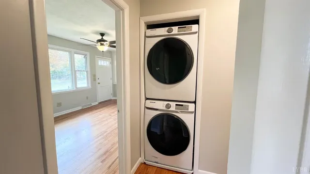 a view of empty room with wooden floor and fan