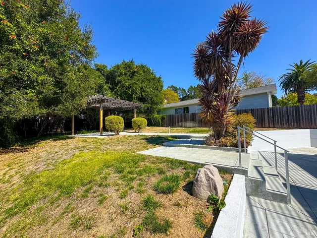a view of house with swimming pool outdoor seating and covered with trees