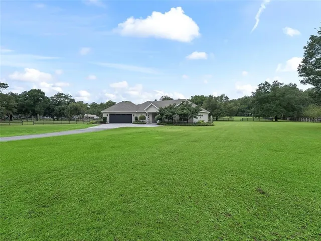 a view of a green field with wooden fence