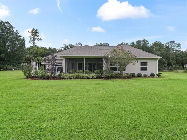 an aerial view of a house with a garden and lake view