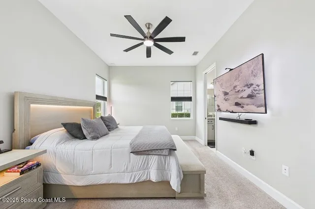 a bedroom with a large bed and a chandelier