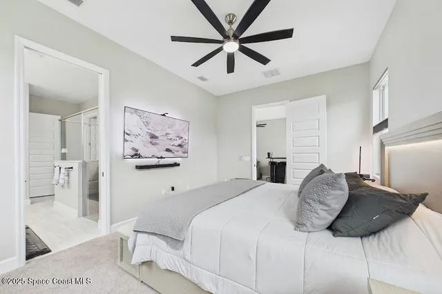 a bedroom with a large bed and a chandelier