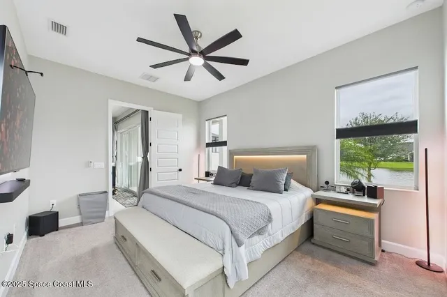 a bedroom with a large bed and a chandelier